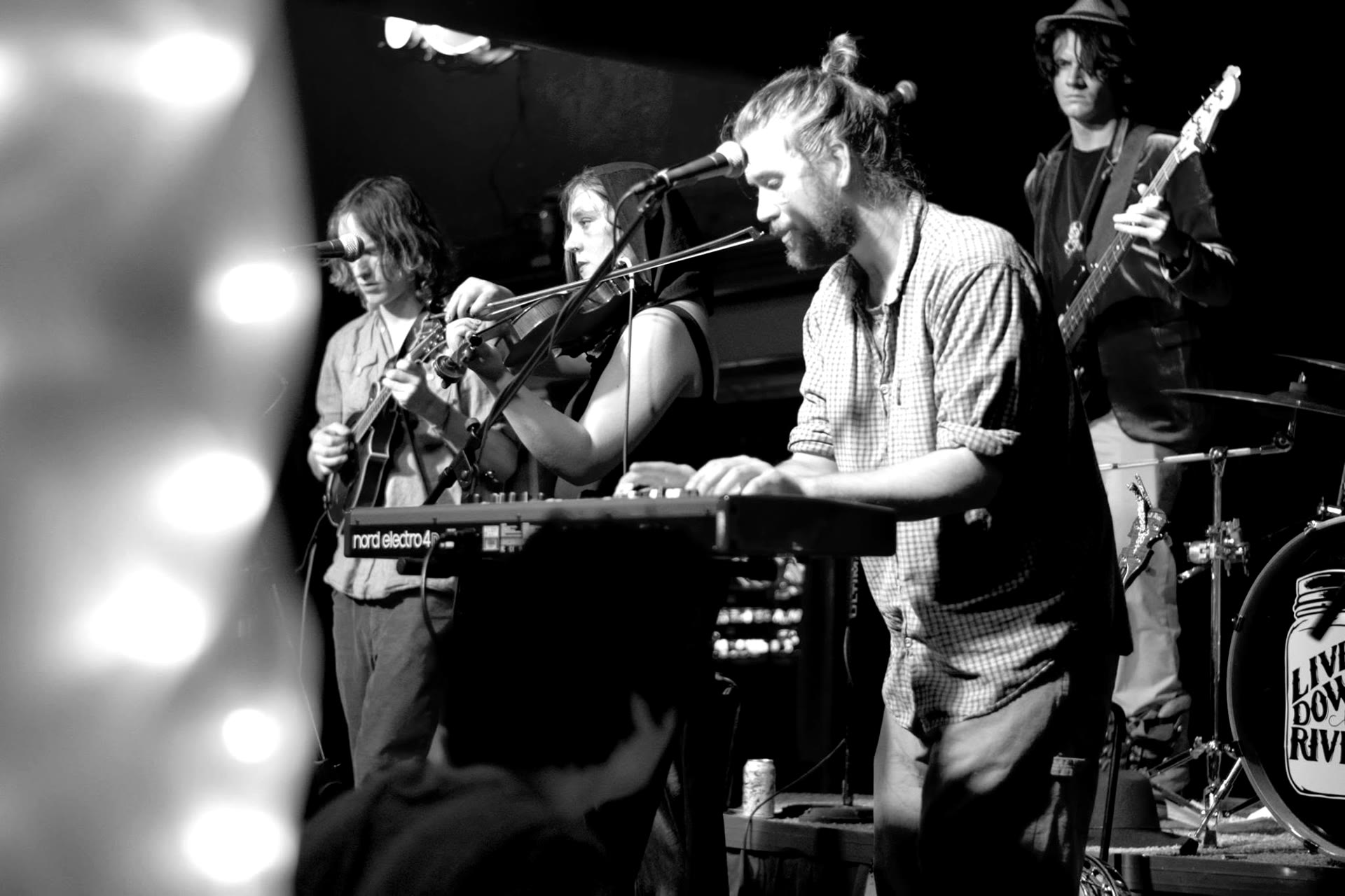 Full band mid-song with a mason jar painted on the bass drum head