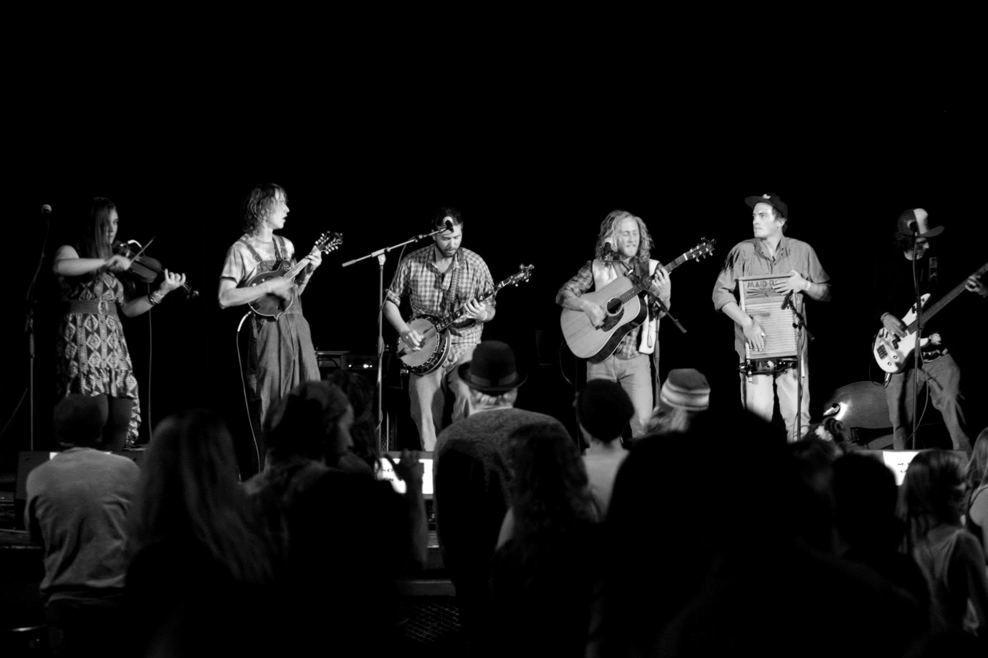 Wide stage shot of the six-piece band with washboard percussion