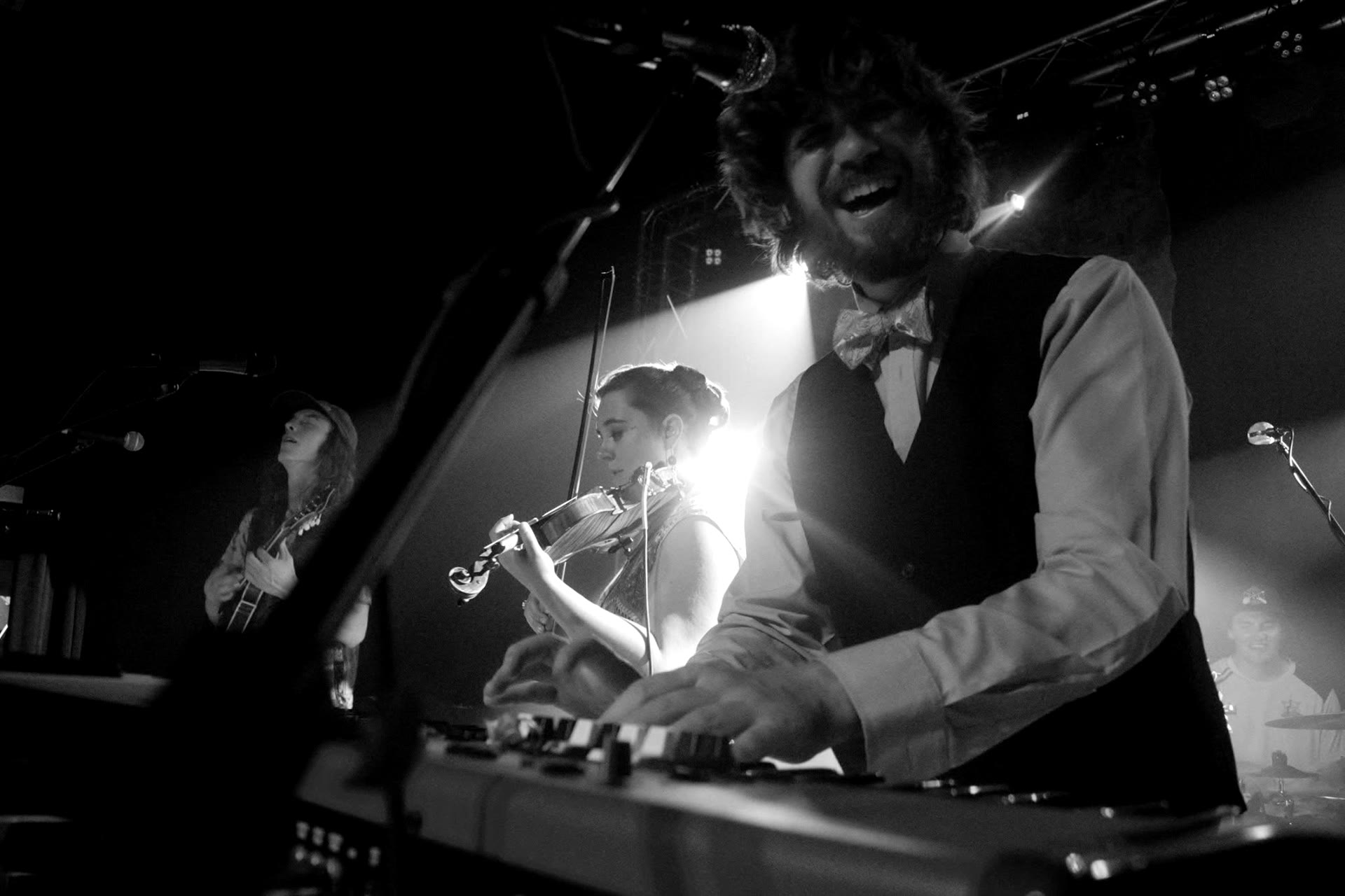Tyler Rice laughing at the keys in a bow tie